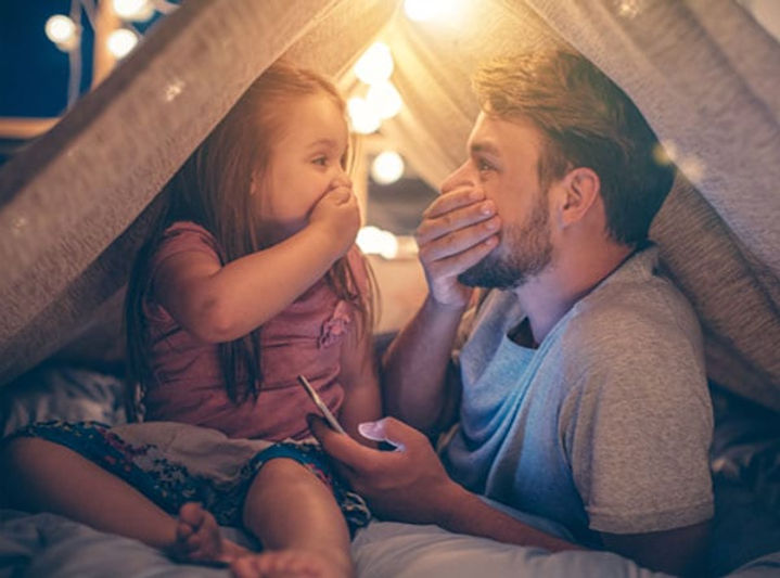Father and daughter in a pretend tent